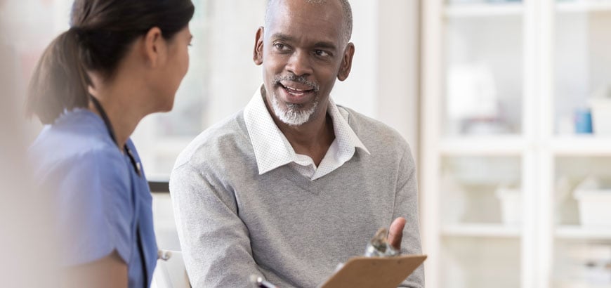 A man sits and chats with his doctor