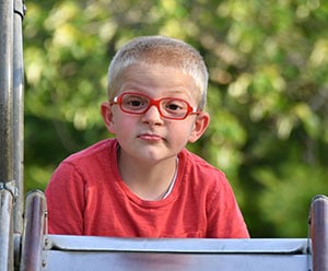 A young boy with red glasses