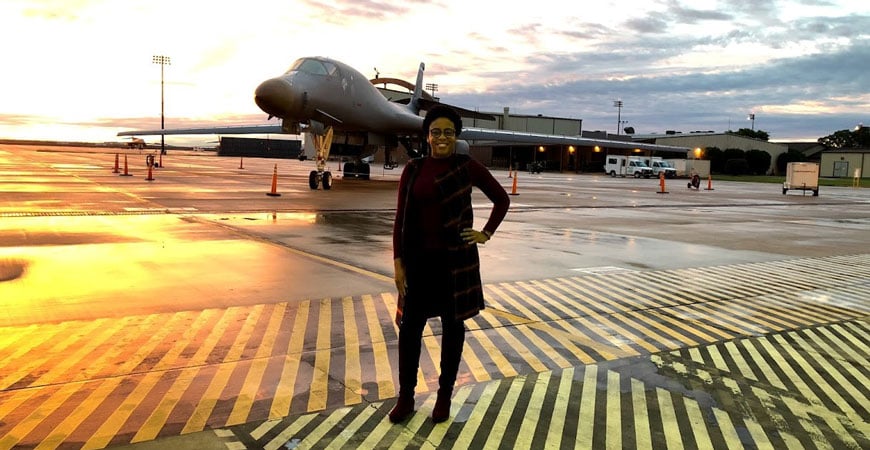 Kedesha Pennant standing in front of an airplane at sunset.