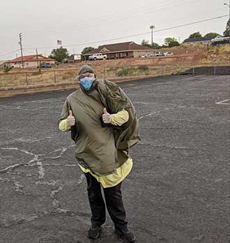 A man wearing protective gear giving two thumbs up